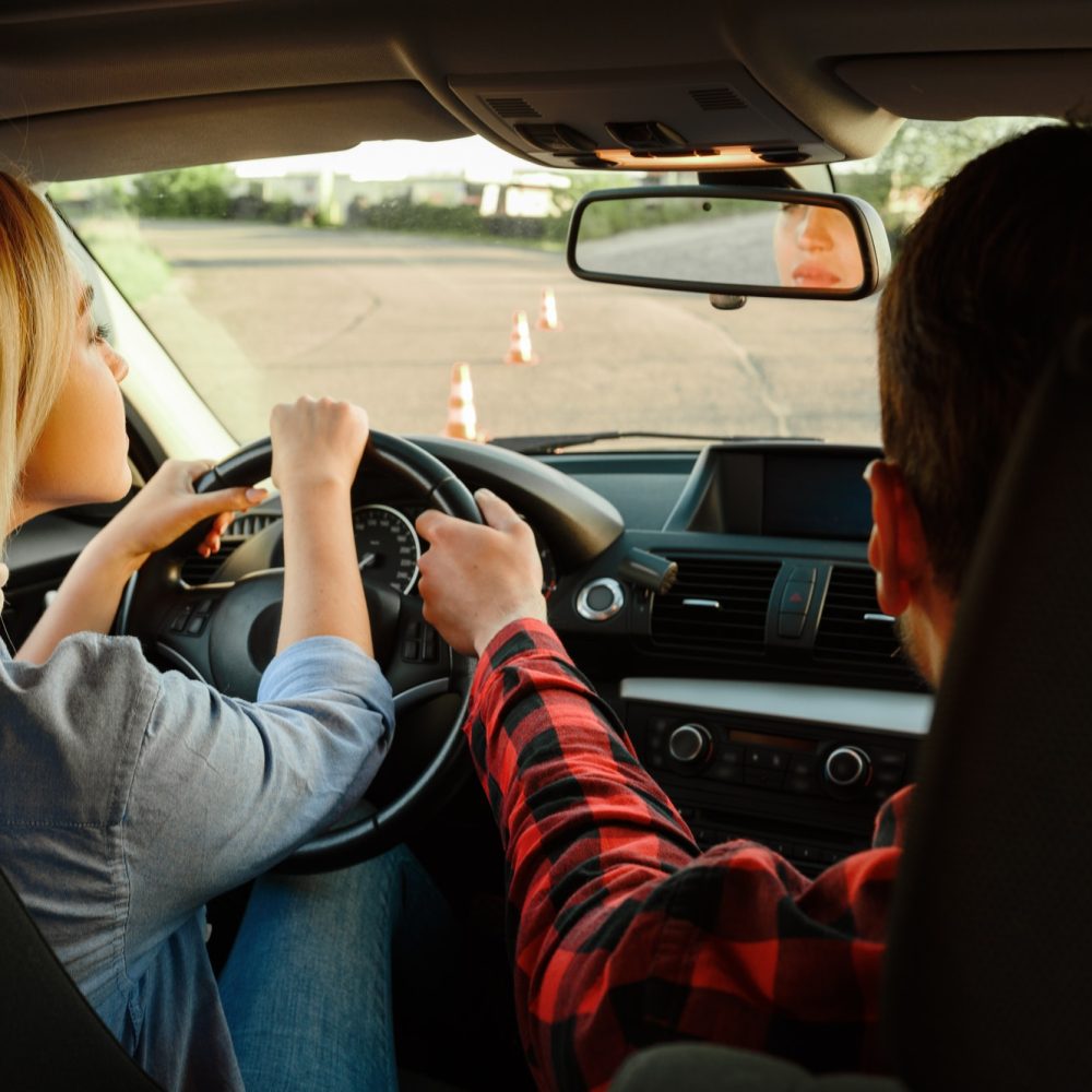 instructor-helps-woman-to-drive-the-car-1.jpg